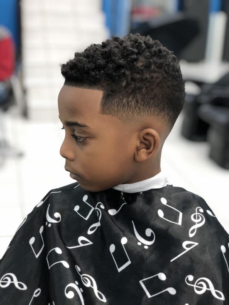 Este corte fade texturizado é perfeito para crianças com cabelos encaracolados, destacando a textura natural com estilo e personalidade.